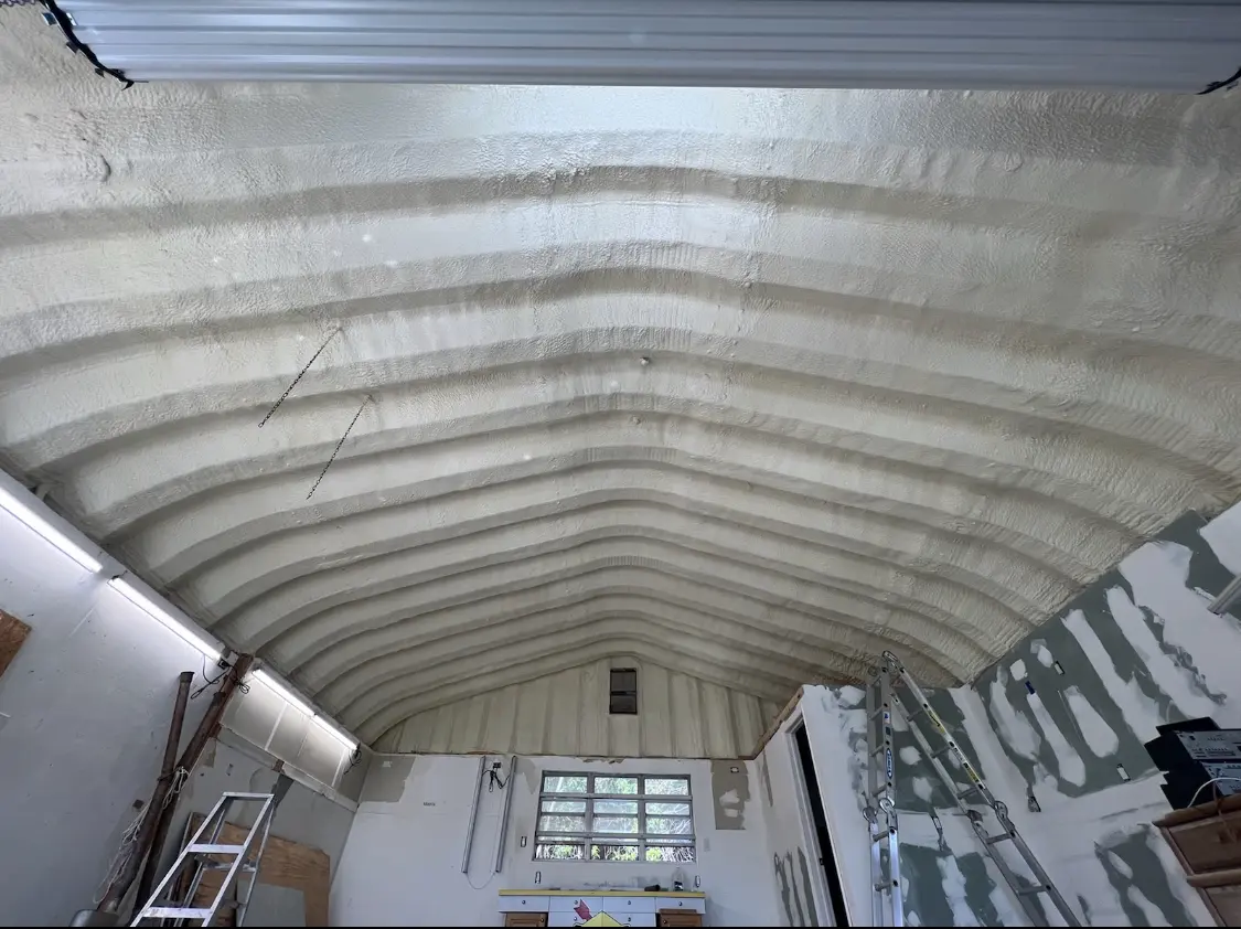 Spray polyurethane foam applied to the underside of a metal roof deck in Massena